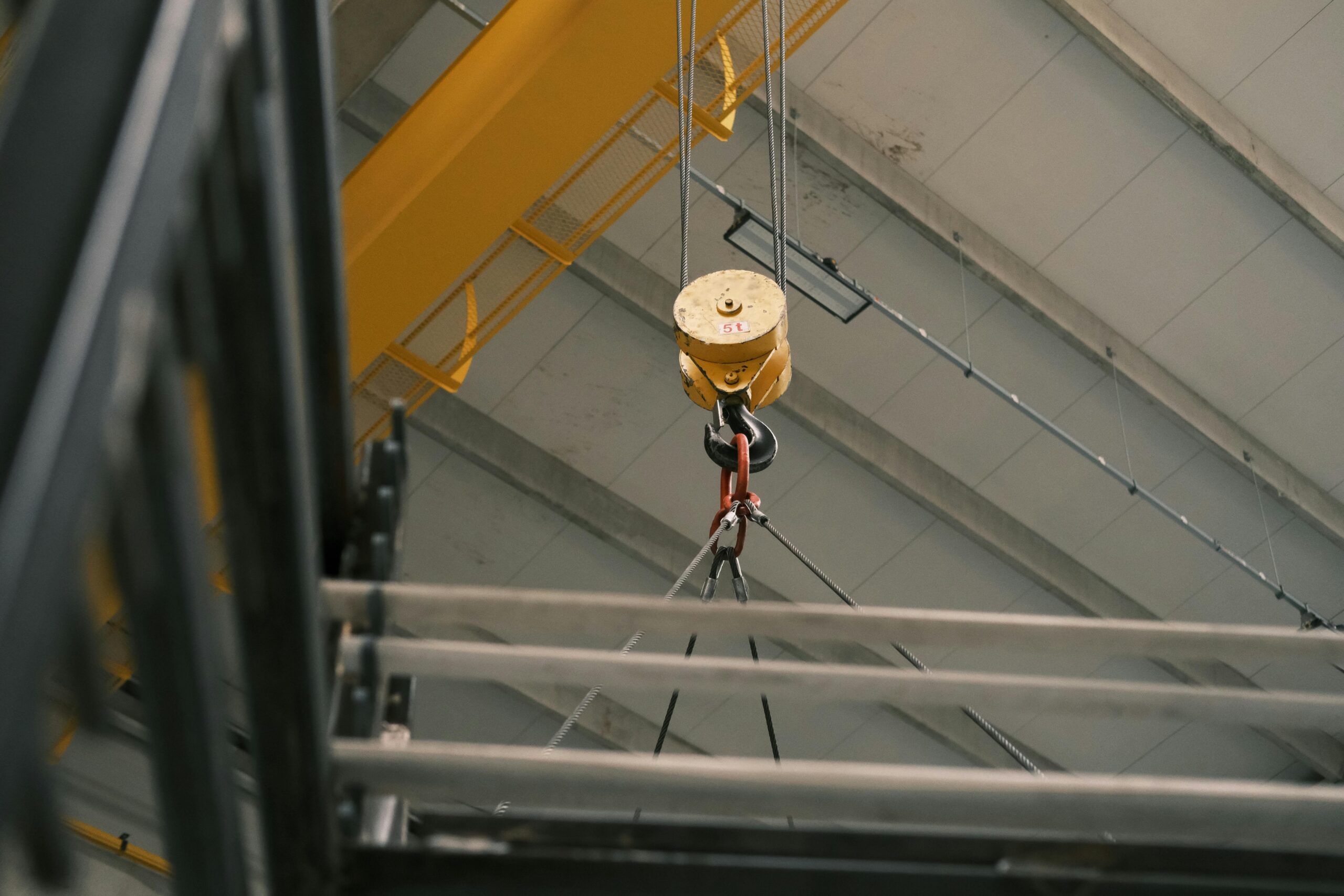 Close-up view of a yellow overhead crane hook in a warehouse in Konya, Türkiye.